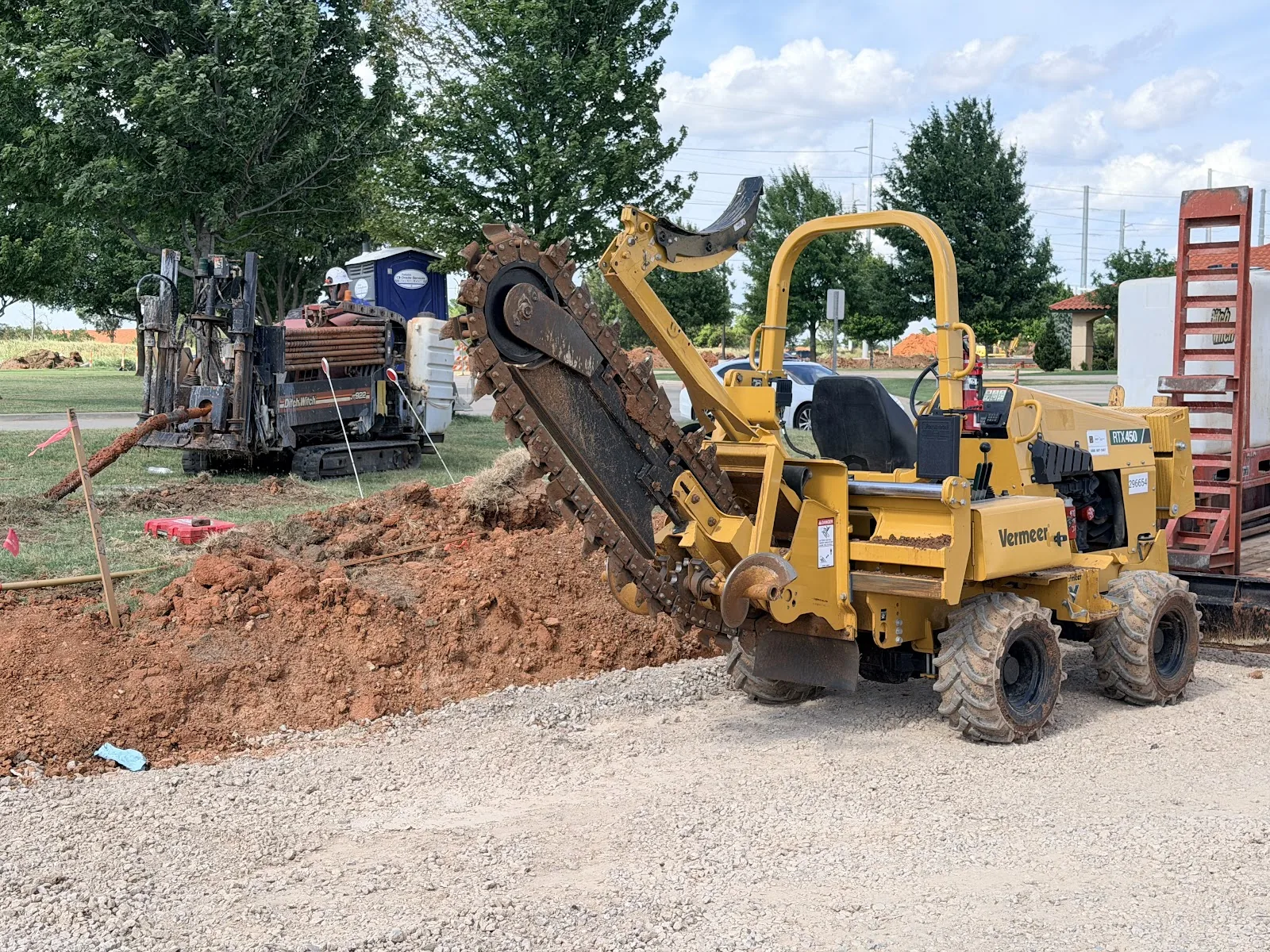 Construction Safety Cones Bore Site Dallas HDD Contractors Trencher cutting an open utility trench on a Dallas property