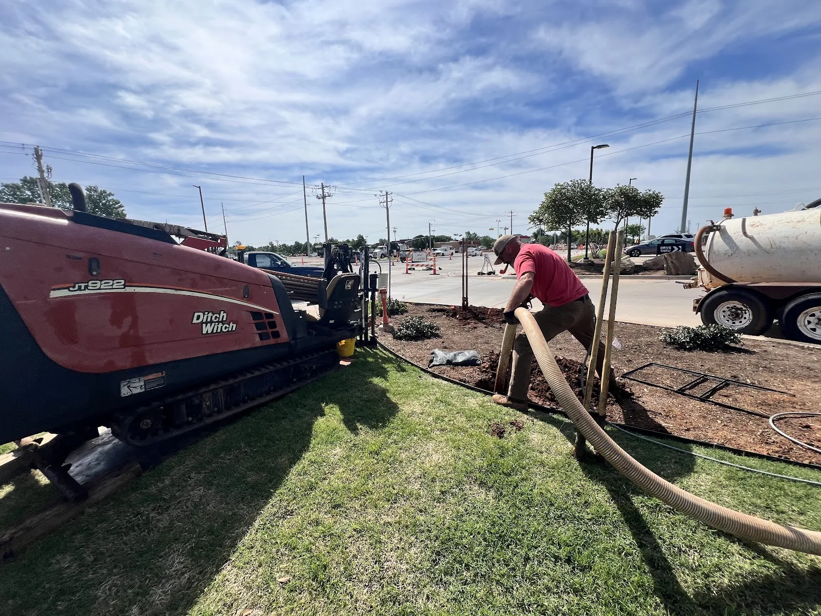 Ditch Witch directional drilling rig running a pilot bore across an open field