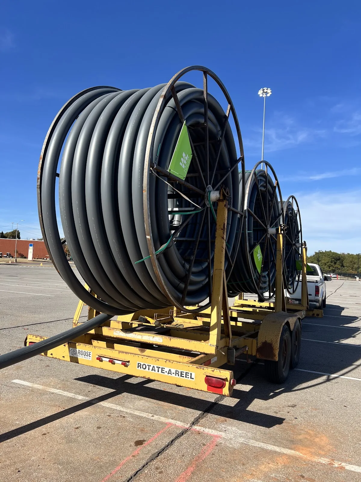 Reels of black HDPE fiber optic conduit staged on a trailer for trenchless fiber installation