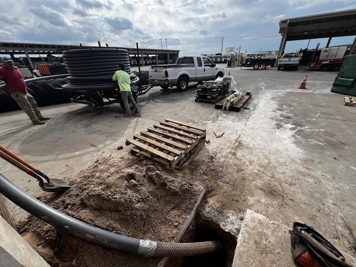 Workers Unloading Cable Reels Dallas HDD Contractors Ditch Witch directional drill positioned for a new utility bore