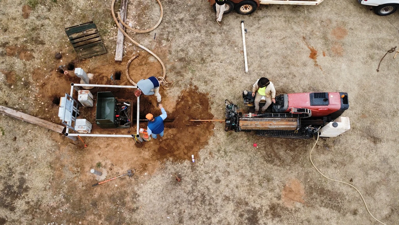 Aerial view of a boring crew and excavated bore pit on a Dallas jobsite