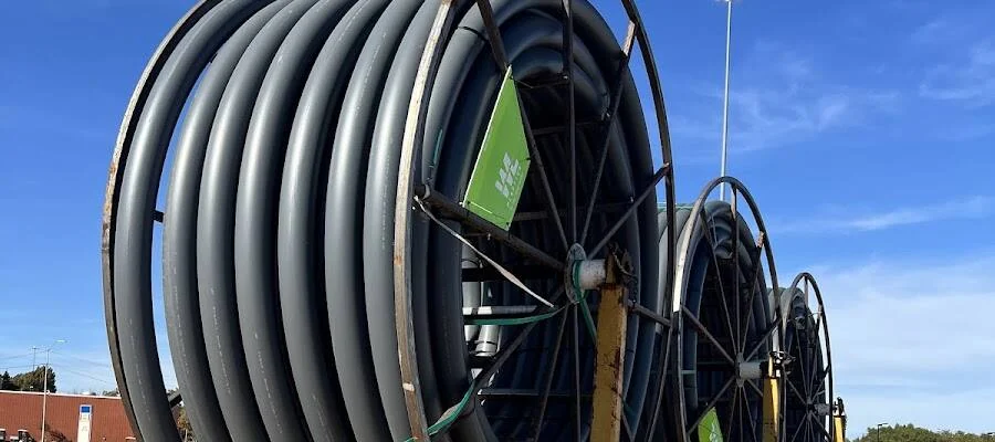 Reels of HDPE conduit on a trailer staged for a telecom and fiber bore